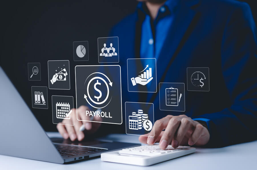 Homem mexendo no computador avaliando os benefícios durante o fechamento de folha.