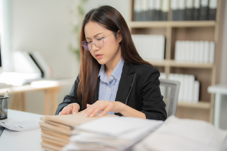 Mulher com papelada no RH público.